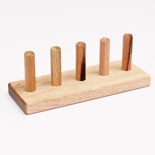 Wooden pegboard with five vertical wooden pegs on a white background