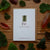 Card with 'Fir' design surrounded by leaves on a wooden surface