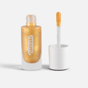 A bottle of Namaki metallic gold nail polish with its cap off, showing the applicator wand coated in the shimmering gold polish against a clean white background.