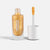 A bottle of Namaki metallic gold nail polish with its cap off, showing the applicator wand coated in the shimmering gold polish against a clean white background.