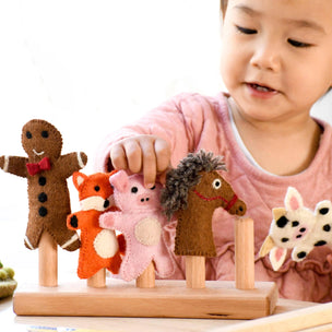 Child playing with felt animal toys on a wooden stand