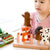 Child playing with a wooden toy featuring animal figures on a white background