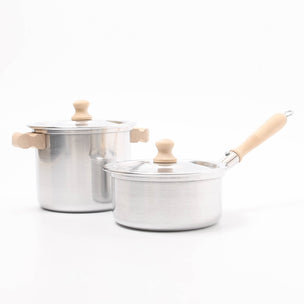 Two stainless steel cookware pots with wooden handles on a white background