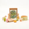 Set of wooden toys with a 'Seasons' book and a small container on a white background