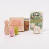 Set of wooden toys including a dog, pink and green animal figures, and a box with a floral design on a white background.