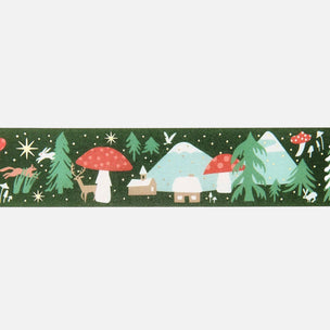 A horizontal strip of whimsical winter forest tape featuring red mushrooms, evergreen trees, cabins, deer, stars, and snow-covered mountains on a dark green background.