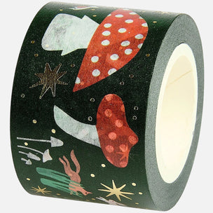 A roll of dark green washi tape featuring a whimsical space-themed pattern with red and white polka-dot mushrooms, silver and white rockets, gold stars, and a small green rocket, shown on a light gray background.