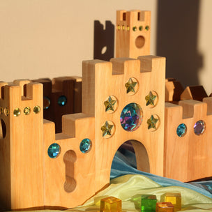 Wooden toy castle with colorful gemstones on a neutral background