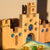 Wooden toy castle with colorful gemstones on a neutral background