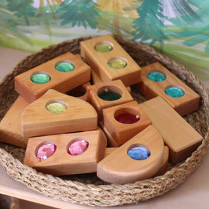 Wooden blocks with colorful beads in a woven basket on a leafy background