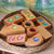 Wooden blocks with colorful beads in a woven basket on a leafy background