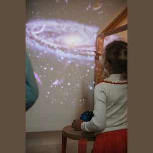 Child watching a projected space scene on a wall
