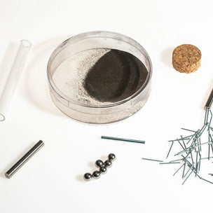 Collection of items including a cork, glass tube, and small objects on a white background