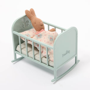 Maileg Light blue crib with a plush bunny toy and pink blanket on a white background