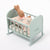 Maileg Light blue crib with a plush bunny toy and pink blanket on a white background