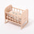Wooden baby crib with floral bedding on a white background