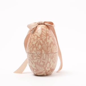 Decorative Maileg egg with floral pattern and ribbon on a white background