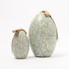 Two Maileg egg-shaped containers with floral patterns on a white background