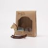 Wooden rocking horse toy next to its packaging on a white background