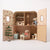 Miniature Maileg cardboard playhouse with toy mice and Christmas tree on a white background