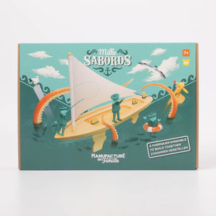 Box for a children's toy sailboat set with illustrations of children and a sailboat on a teal background.