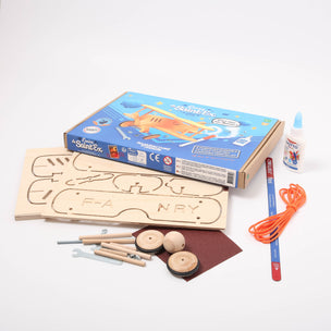 Wooden toy kit with components and packaging on a white background