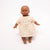 Doll wearing a patterned dress on a white background