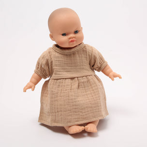 Baby doll wearing a beige dress on a white background