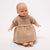 Baby doll wearing a beige dress on a white background