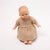 Baby doll wearing a beige dress on a white background