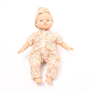Baby doll wearing a floral outfit and headband on a white background