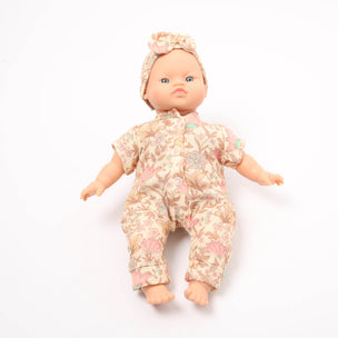 Baby doll wearing a floral outfit and headband on a white background