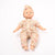 Baby doll wearing a floral outfit and headband on a white background