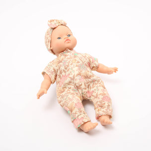 Baby doll wearing a floral outfit and headband on a white background