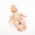 Baby doll wearing a floral outfit and headband on a white background