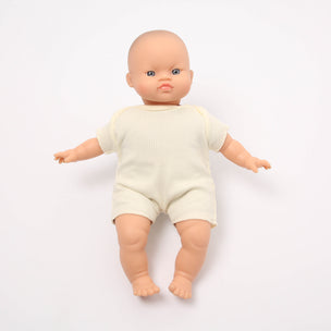 Baby doll wearing a cream outfit on a white background