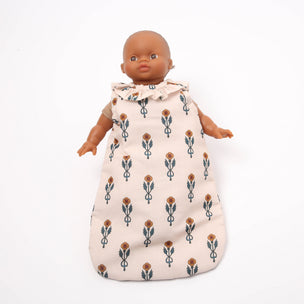 Baby doll wearing a floral patterned baby wrap on a white background
