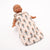 Doll wearing a floral patterned baby wrap on a white background
