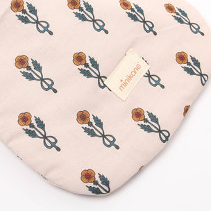 Fabric with floral pattern and 'minikone' brand tag on a beige background