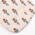 Fabric with floral pattern and 'minikone' brand tag on a beige background