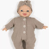 Baby doll wearing a brown outfit with buttons and a matching headband on a white background