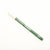 Green makeup pencil with white cap on a white background