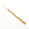 Gold-colored cosmetic pencil with 'L'ANIME' branding on a white background