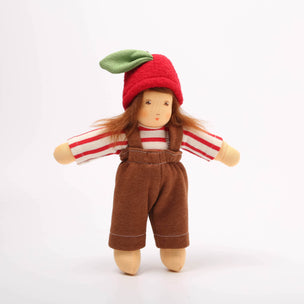 Small doll with a red hat, brown overalls, and striped shirt on a white background