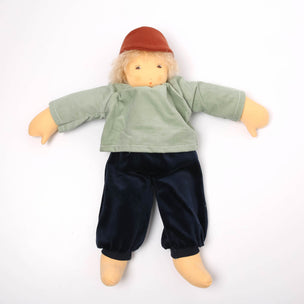 Doll wearing a green shirt and navy pants on a white background