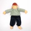 Doll wearing a green shirt and navy pants on a white background