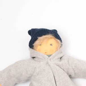 Doll wearing a gray jacket, brown pants, and blue hat on a white background