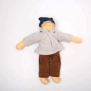 Doll wearing a gray coat, brown pants, and a blue hat on a white background