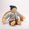 Textile doll wearing a blue hat, gray coat, and brown pants on a white background
