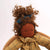 Textile doll with plaid coat and green pants on a white background